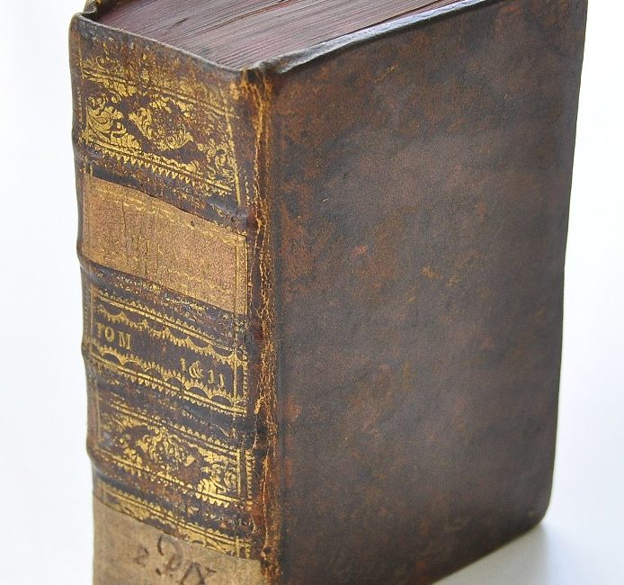 Oryginalna tekturowo-skórzana oprawa dwutomowego wydania rozprawy Woltera ze złoceniami i szyldzikami (1751)
